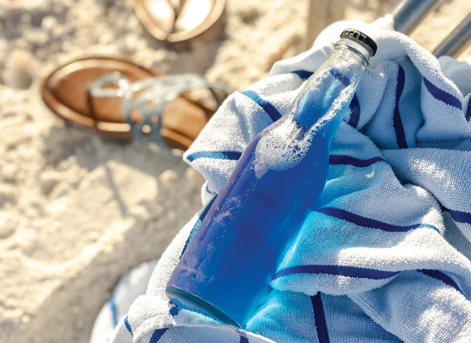 dark blue drink on towel at beach