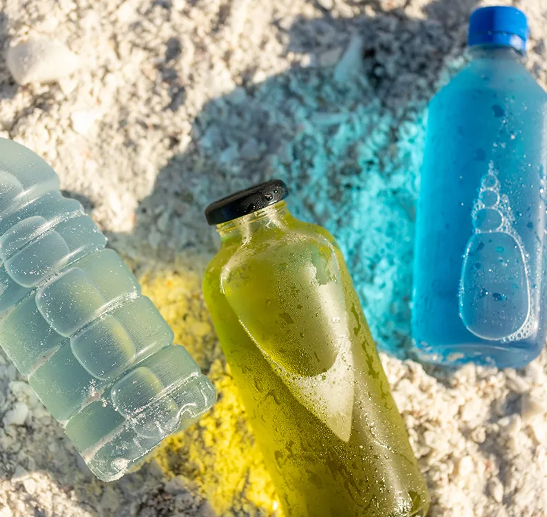 green and blue drinks in bottles on beach